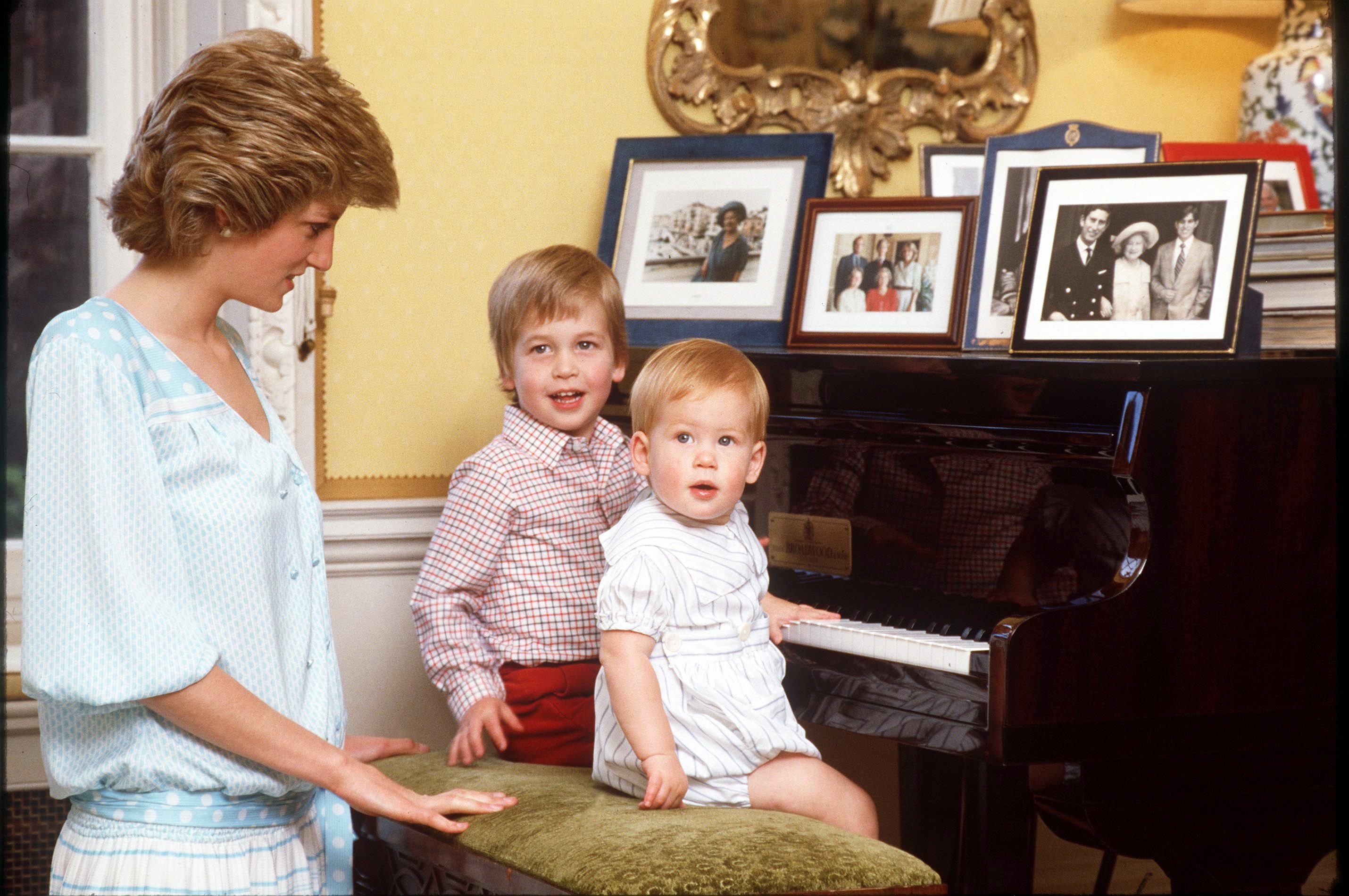     Princess Diana with Prince William and Prince Harry at the piano at home at Kensington Palace in 1985 |  Source: Getty Images